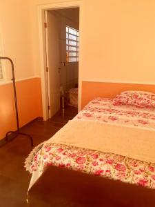 坎皮纳斯Franca Maya Hostel的一间卧室配有一张带花卉床罩的床