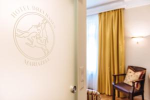 玛利亚采尔三只兔酒店的墙上有标志的酒店客房
