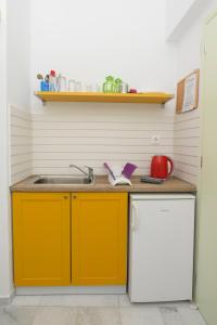 卡塔波拉Porto Katapola Pension的厨房配有黄色橱柜和水槽