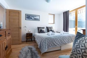 夏蒙尼-勃朗峰Yeti Lodge Chalets & Apartments的白色的卧室设有床和窗户