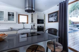夏蒙尼-勃朗峰Yeti Lodge Chalets & Apartments的厨房配有黑色台面和窗户