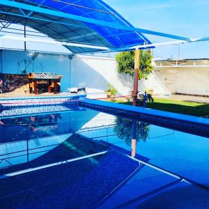 瓦兹特佩克Casa el paraíso的蓝色游泳池,上面有蓝色的遮阳伞