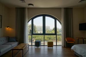 耶路撒冷Apartique Hotel的带沙发和大窗户的客厅