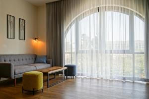 耶路撒冷Apartique Hotel的带沙发和大窗户的客厅