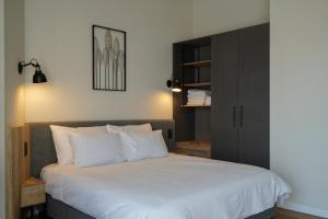 耶路撒冷Apartique Hotel的一间卧室配有一张白色的床和黑色橱柜