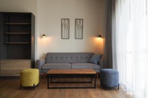 耶路撒冷Apartique Hotel的客厅配有沙发和两把椅子