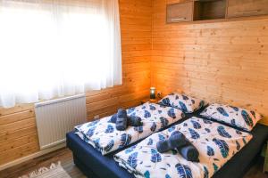 陶波尔曹NaposOldal Vendégház的木制客房内的一间卧室配有两张床