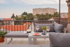 希贝尼克Marijola apartments的阳台配有沙发和2杯葡萄酒