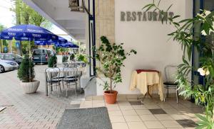 比斯特里察德切巴尔比斯特里察酒店的一间带桌椅和遮阳伞的餐厅