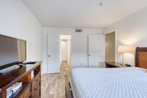 德斯坦Crystal Sands Condominiums的一间卧室配有一张床和一台平面电视