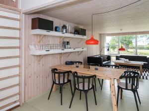 埃贝尔托夫特8 person holiday home in Ebeltoft的厨房以及带木桌和椅子的用餐室。
