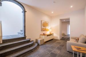 蓬塔德尔加达Casas Amarelas Azores的一间带楼梯和沙发的客厅