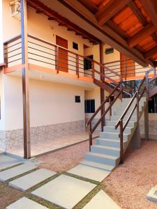 戈亚斯州上帕莱索Pousada Capim Dourado的楼梯通往带木制天花板的建筑