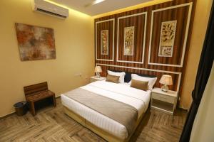 利雅德Qasr Alhanen Furnished Apartments的一间卧室配有一张大床和两张带台灯的桌子。