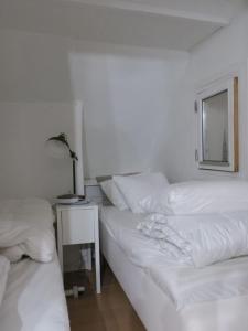 哥本哈根ApartmentInCopenhagen Apartment 1316的一间卧室设有两张床和一张桌子及窗户