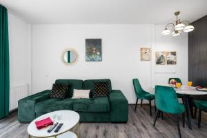 波兹南Sleepway Apartments- Garbary 100-46的客厅配有绿色沙发和桌子