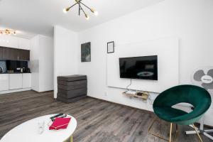 波兹南Sleepway Apartments- Garbary 100-46的客厅配有电视和绿色椅子