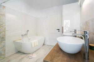 班斯卡-比斯特里察The Luxury Penthouse的浴室配有大型白色浴缸和2个盥洗池