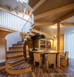 大阪ARCHITEKTON -the villa Tennoji-的厨房以及带桌子和楼梯的用餐室。