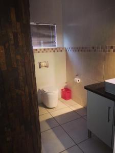 纳布姆斯普雷特AAA Rose Garden Guesthouse的浴室设有白色卫生间和红色篮子