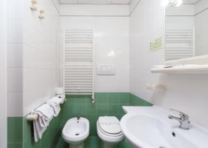 比萨卡萨贝塔尼亚酒店的绿色和白色的浴室设有卫生间和水槽