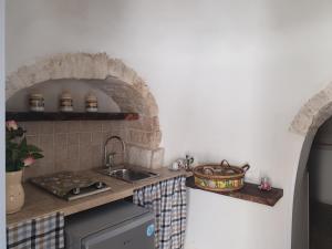 阿尔贝罗贝洛贾迪诺德特鲁利酒店的厨房配有带水槽和台面的台面