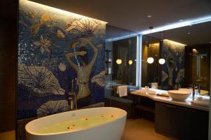 胡志明市HOME Hotel的带浴缸和马赛克墙的浴室。