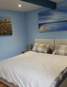 KentMango Lodge的卧室配有一张床,墙上挂有绘画作品