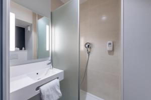 乌伊斯特勒昂B&B HOTEL Ouistreham的带淋浴、水槽和镜子的浴室