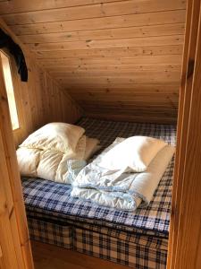 霍夫登Ramsbu Hovden Fjellpark sen utsjekk的小木屋内的一张床位,配有两个枕头