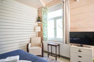 瑙沃Köpmans的一间卧室配有一张床、一台电视和一把椅子