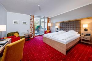 Hagen布勒兰德酒店的酒店客房设有一张大床和一间客厅。