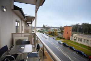 谢珀顿谢珀顿凯斯特酒店的阳台配有桌子,享有街道的景色