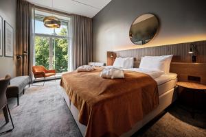 奥斯陆Karl Johan Hotel的配有一张大床和镜子的酒店客房