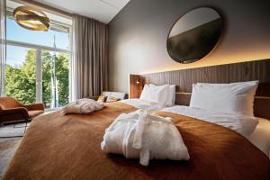 奥斯陆Karl Johan Hotel的卧室配有一张大床,墙上设有大镜子