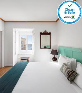 里斯本帕拉西奥贾梅士 - 里斯本服务式公寓的白色的卧室设有一张大床和一个窗户