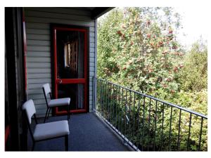 汉默温泉拉什伍德汽车旅馆的门廊,两把椅子,一扇红色的门和一棵树