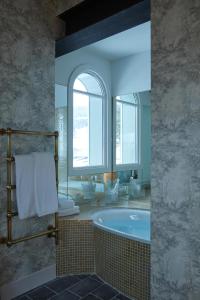 梅杰夫Grand Hotel Soleil d'Or的一间带浴缸和大镜子的浴室