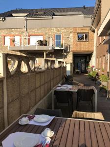 拉朗Hotel-Restaurant Zum Onkel Jonathan的一个带桌椅的户外庭院和一个阳台