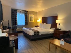 奥尔巴尼奥尔巴尼机场旅程住宿旅馆和套房酒店的酒店客房设有一张大床和一张沙发。