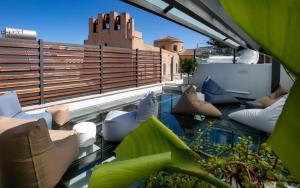 特拉帕尼Azzoli Trapani - Apartments&Skypool - Adults Only的屋顶阳台配有枕头和椅子
