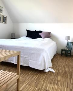 哥本哈根Villa Stjerneklar的卧室设有一张白色大床和木地板