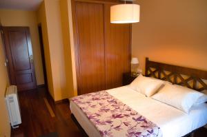 格罗韦Apartamento en Beiramar的一间卧室配有一张床和一盏灯