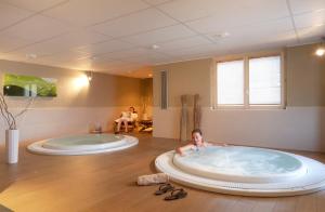 圣热尔韦莱班SOWELL HOTELS Mont Blanc et SPA的男孩躺在浴室的大浴缸里