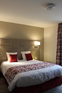 Vaux-sous-Aubigny勒瓦沃奥克斯酒店的一间卧室配有一张带红色枕头的大床