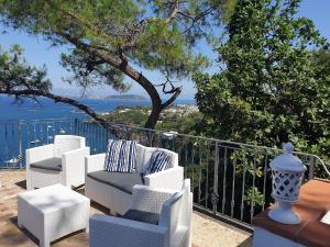 伊斯基亚L'Incanto Suites Ischia的一组椅子坐在俯瞰大海的阳台