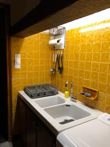 ChabottesPont de Frappe的厨房设有水槽和黄色瓷砖墙。