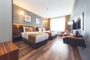 LadikHilas Thermal Resort Spa & Aqua的大型酒店客房设有两张床和一张书桌