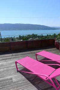 维里尔·杜·拉克Le Clos Du Lac - location de chambres的美景甲板上的粉红色椅子和桌子