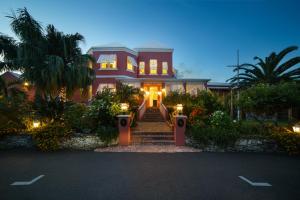 汉密尔顿皇家棕榈酒店 的一座带灯的大粉色房子
